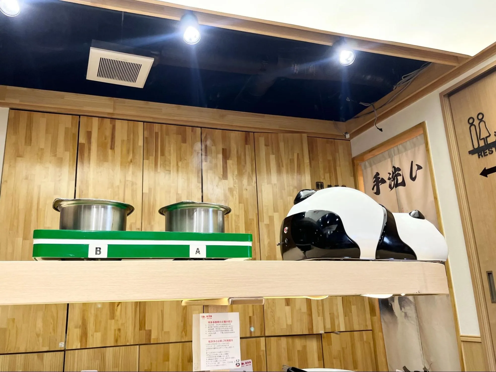 レーンに乗ってスープを運んでくるパンダ型配膳ロボット
