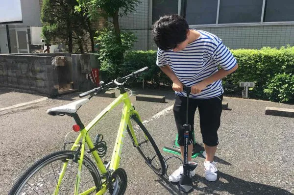 自転車のタイヤに空気を入れる人