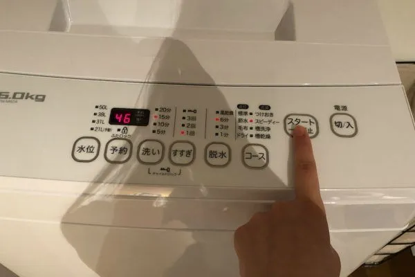 洗濯機のスタートボタンを押す