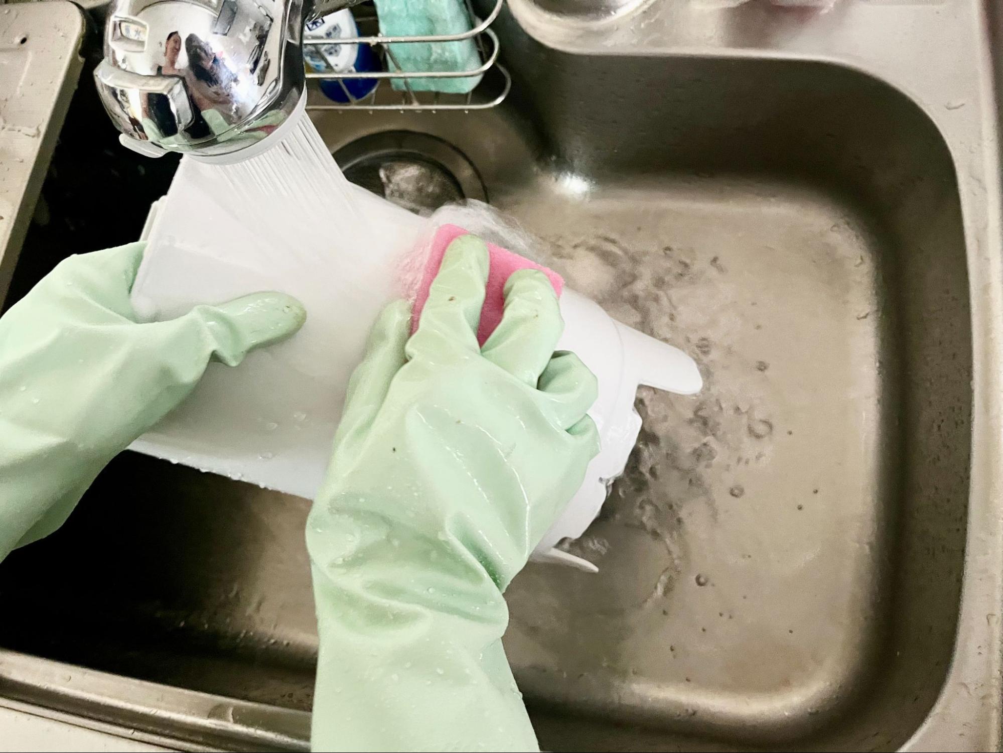 加湿器の水タンクを流水で洗う様子