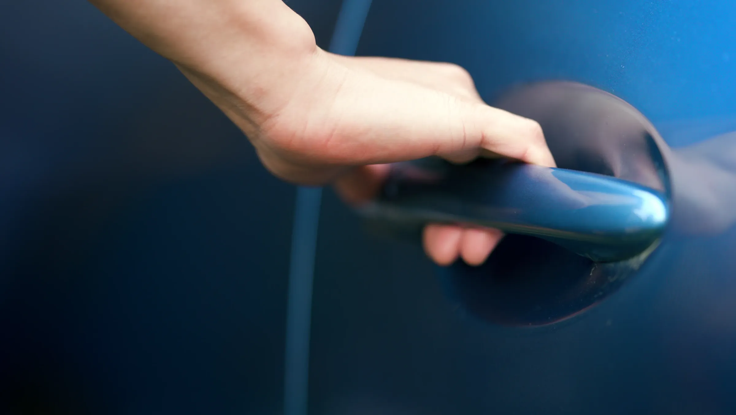 車のドアノブを掴む男性の手